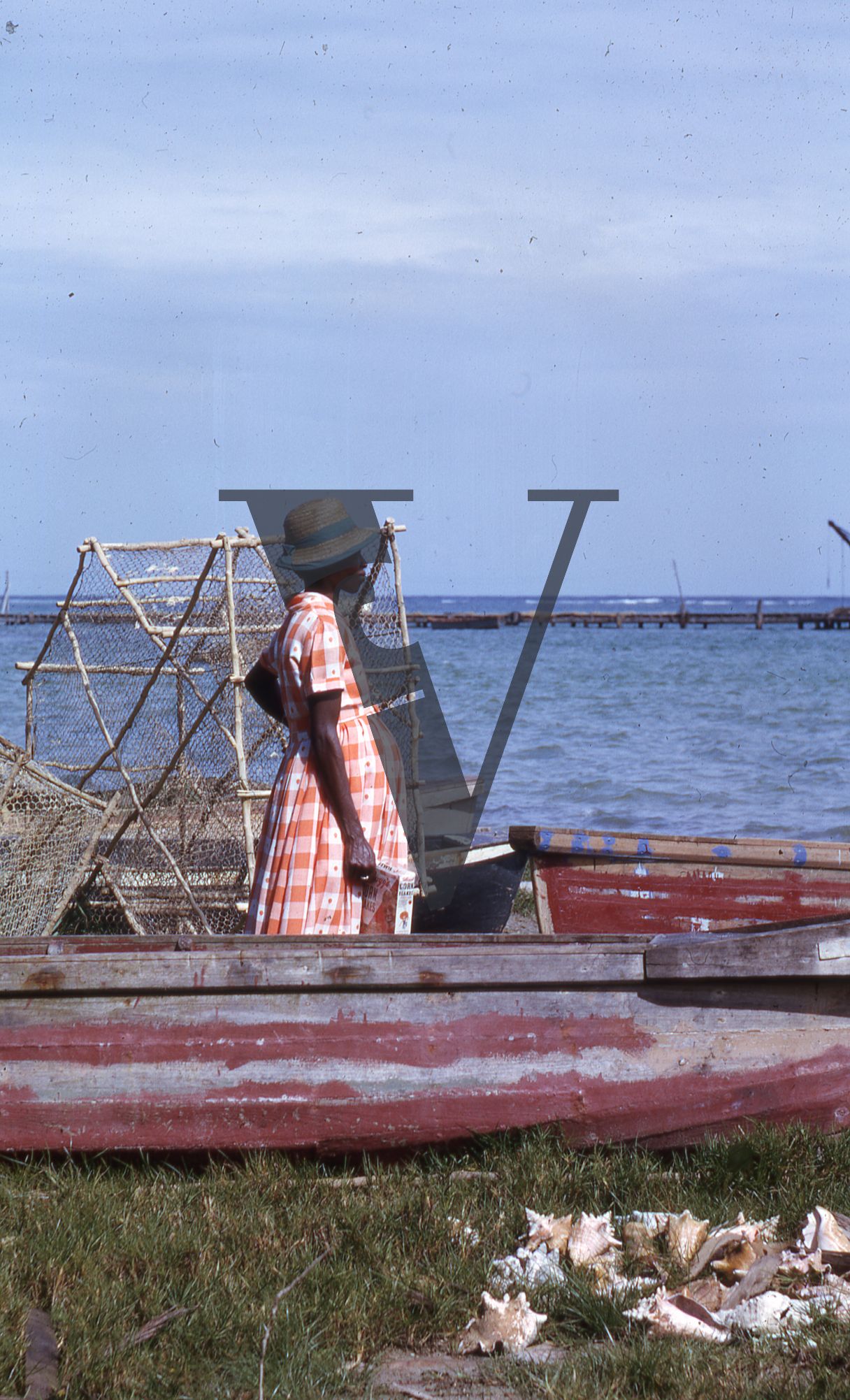 Jamaica, Woman in fishing boat looking towards sea.