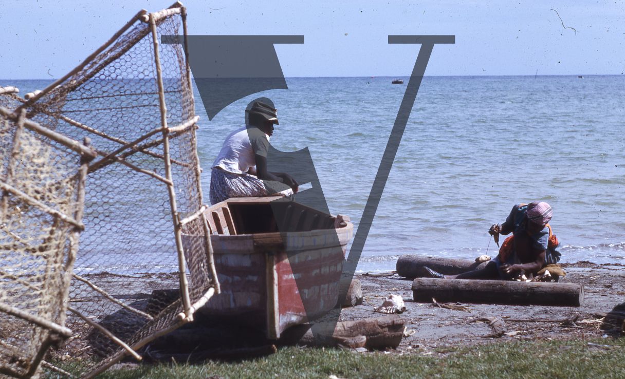 Jamaica, Woman in fishing boat looking towards sea.