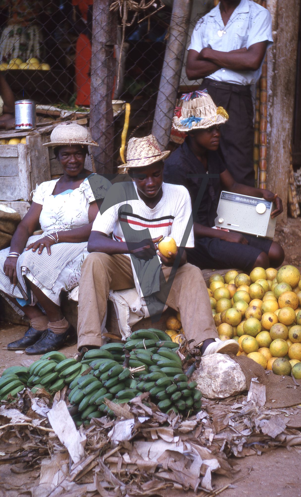 Jamaica, Boy peels fruit, boy holds radio while woman stares at camera.