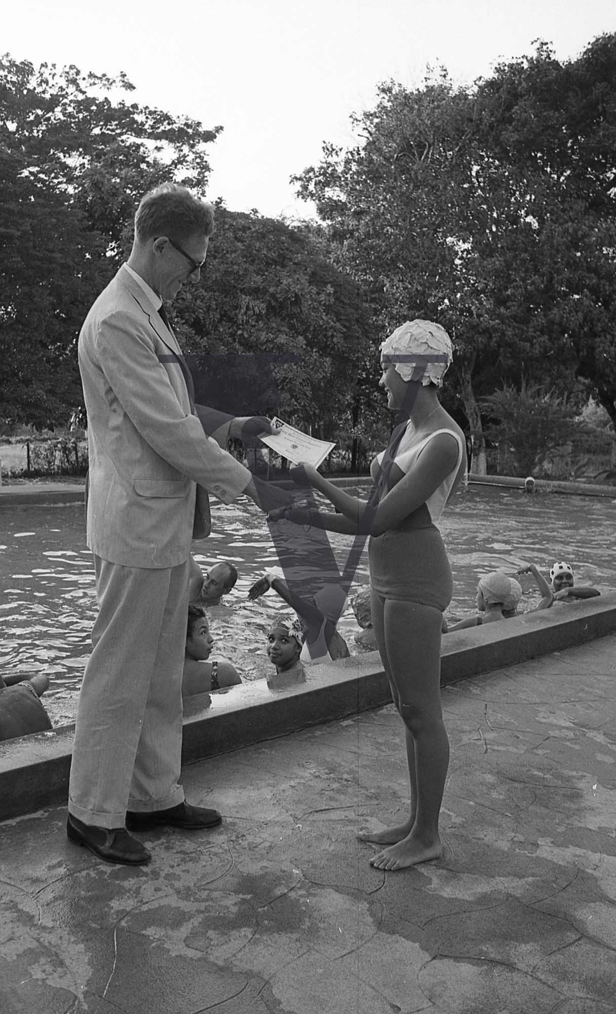 Jamaica, White man awards girl in swimming costume with certificate.