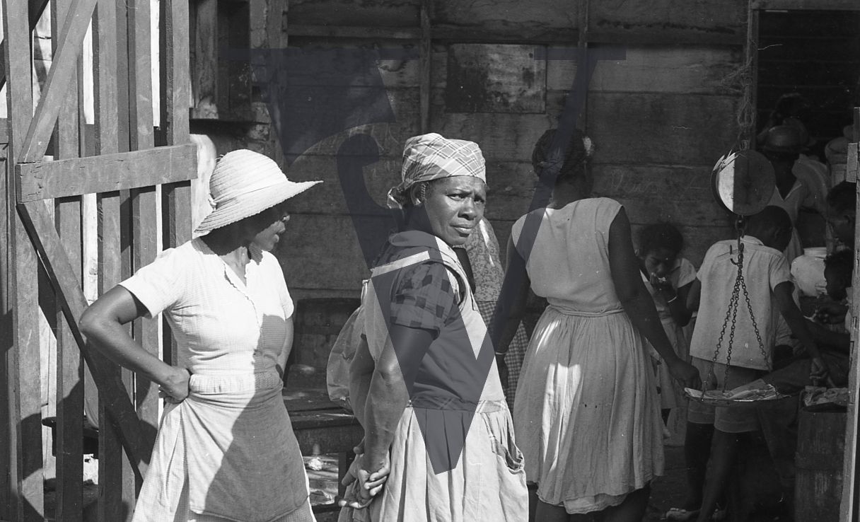 Jamaica, Market trader looks on at camera.