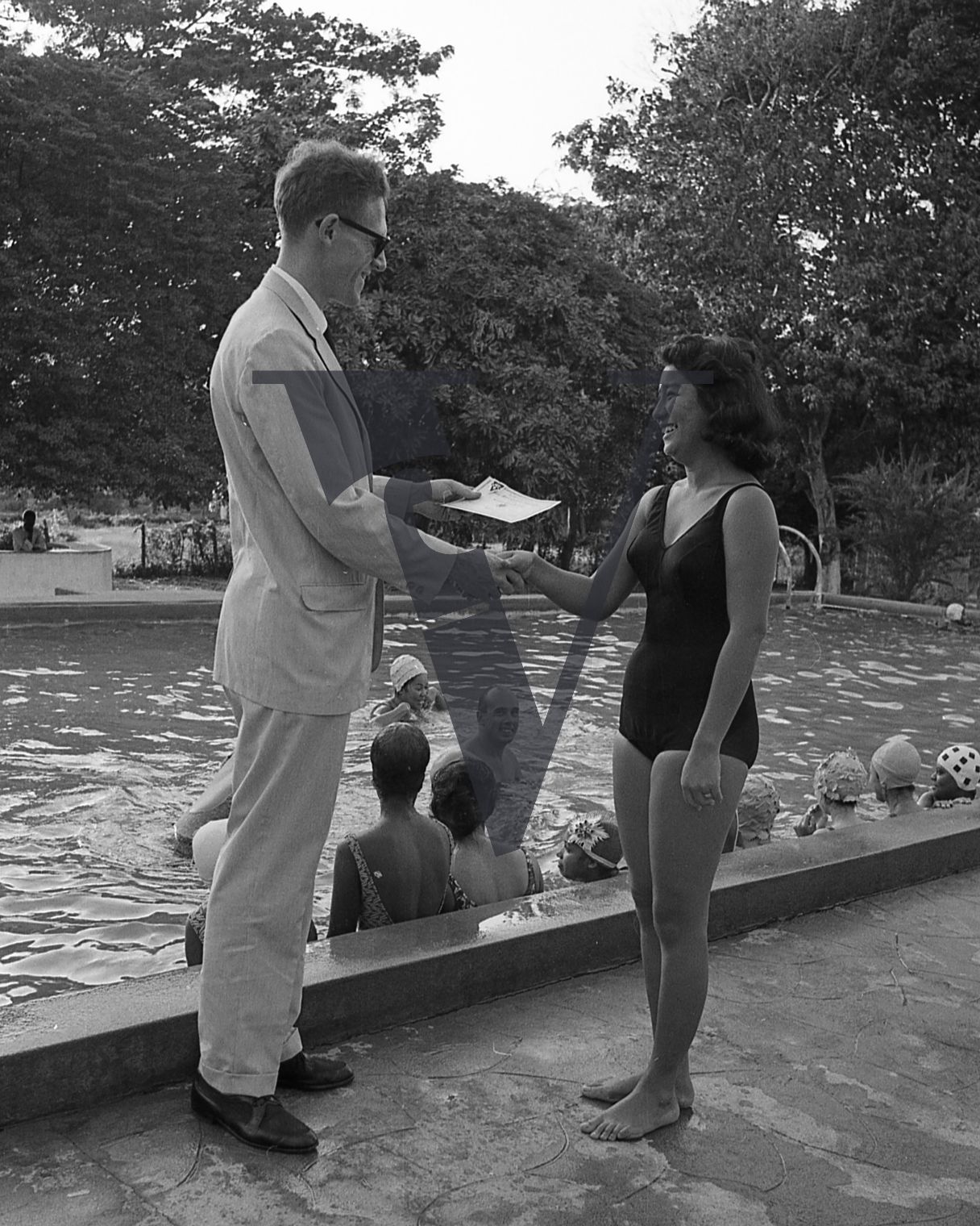 Jamaica, White man awards girl in swimming costume with certificate.