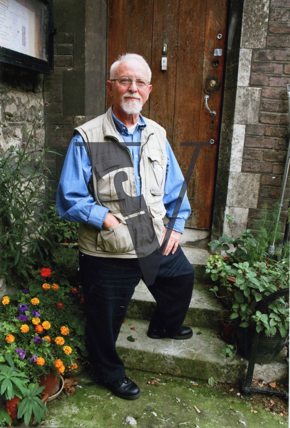 Leon Redler, portrait, standing outside house.